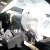 A deployed airbag and damaged dashboard inside a car, indicating a recent collision.