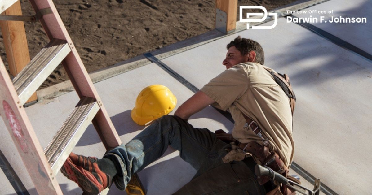 A construction worker lies on the ground near a ladder and a yellow hard hat, appearing to have fallen, with visible tools on his belt.